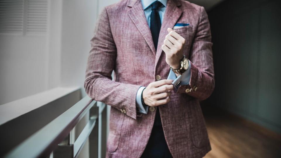 Hombre con traje ajustándose el puño de la camisa, imagen de confianza y decisión