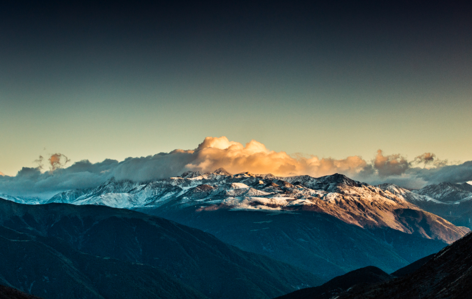 Cordillera al amanecer con nubes doradas, horizonte y visión